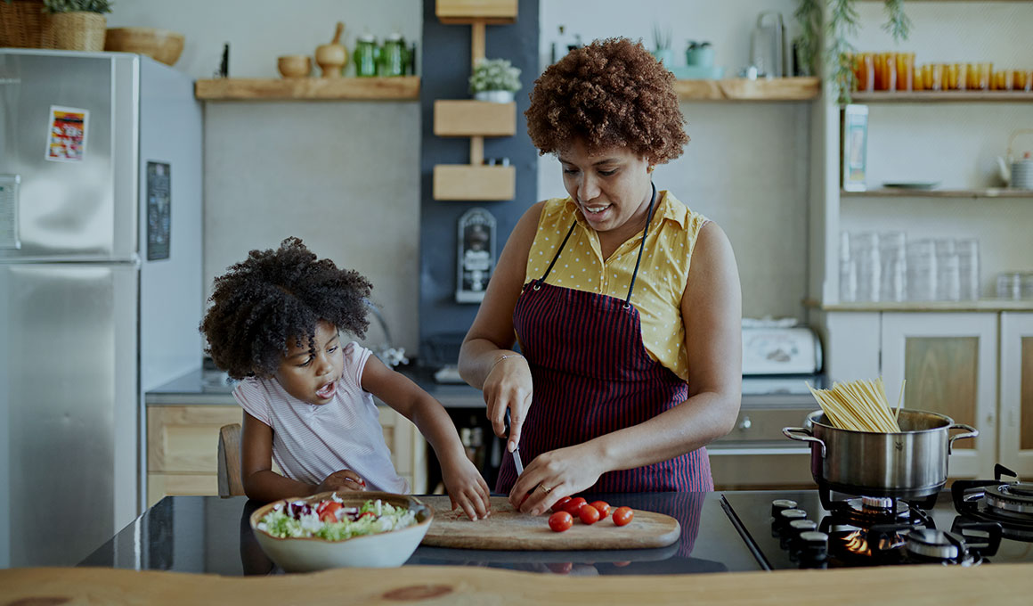 Image of mother and daughter cooking in a kitchen.