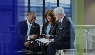 Three Fifth Third Bank associates discussing unknown details on a tablet.